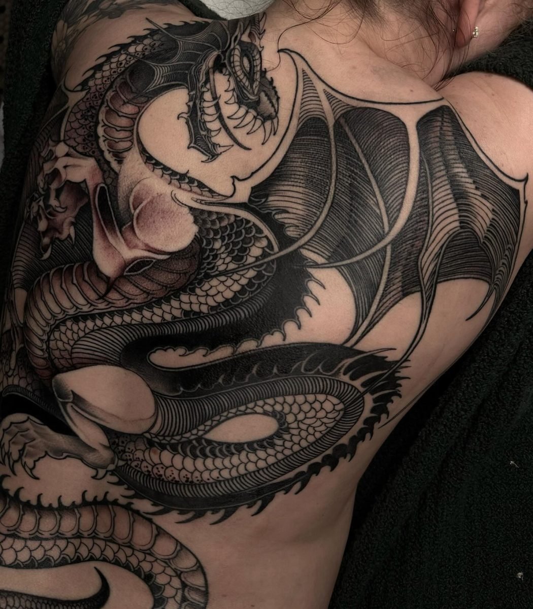 gothic blackwork dragon tattoo on back and shoulder with bold linework, dark shading and detailed scales