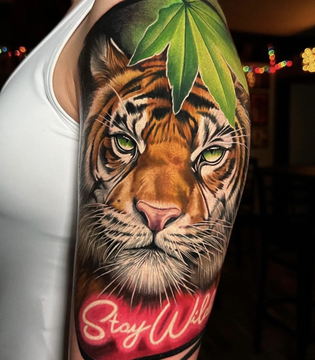 realistic tiger tattoo with intense green eyes, detailed fur texture and vibrant color realism on upper arm